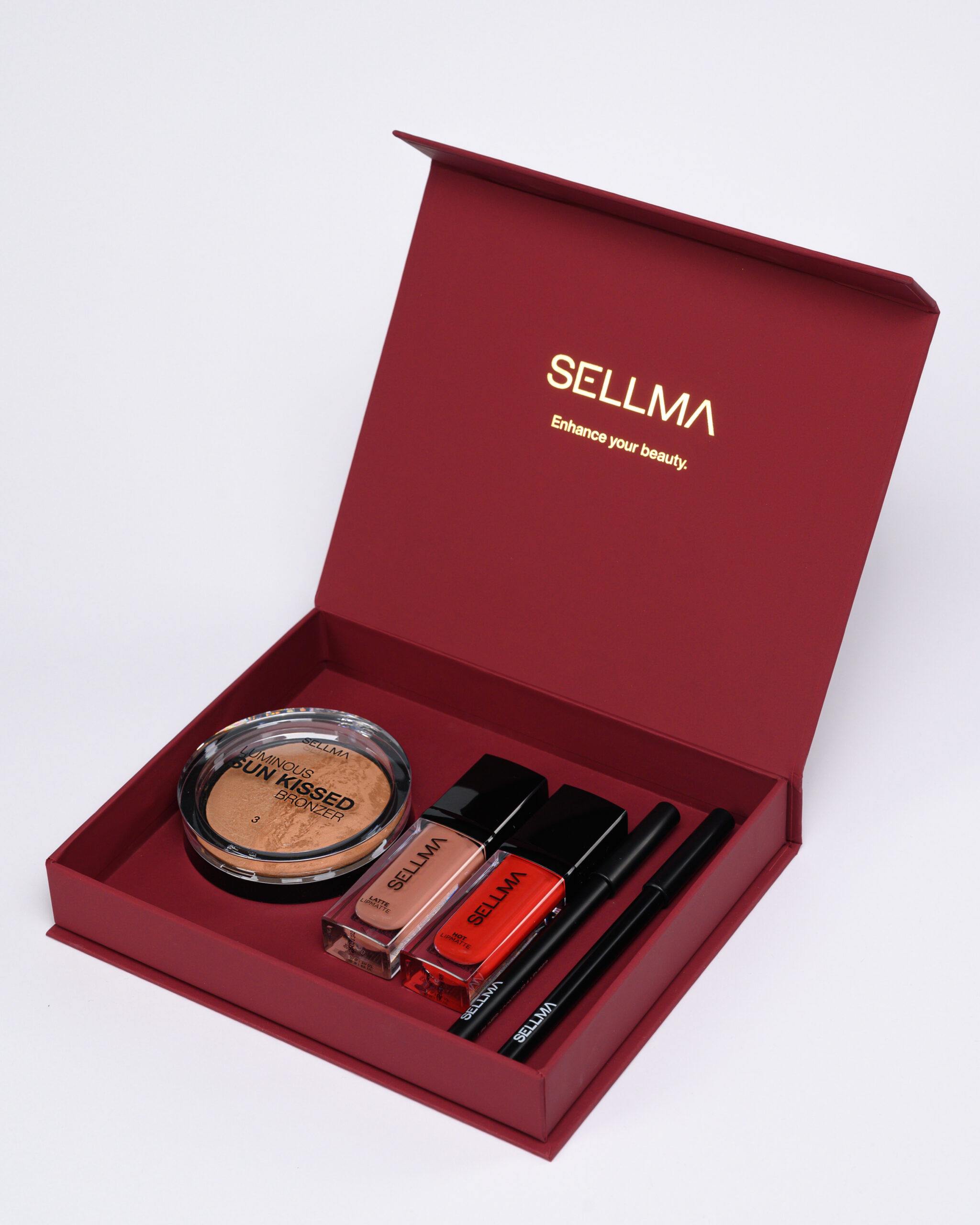 Open red cosmetic box with powder, lip glosses, and lip pencils arranged inside.