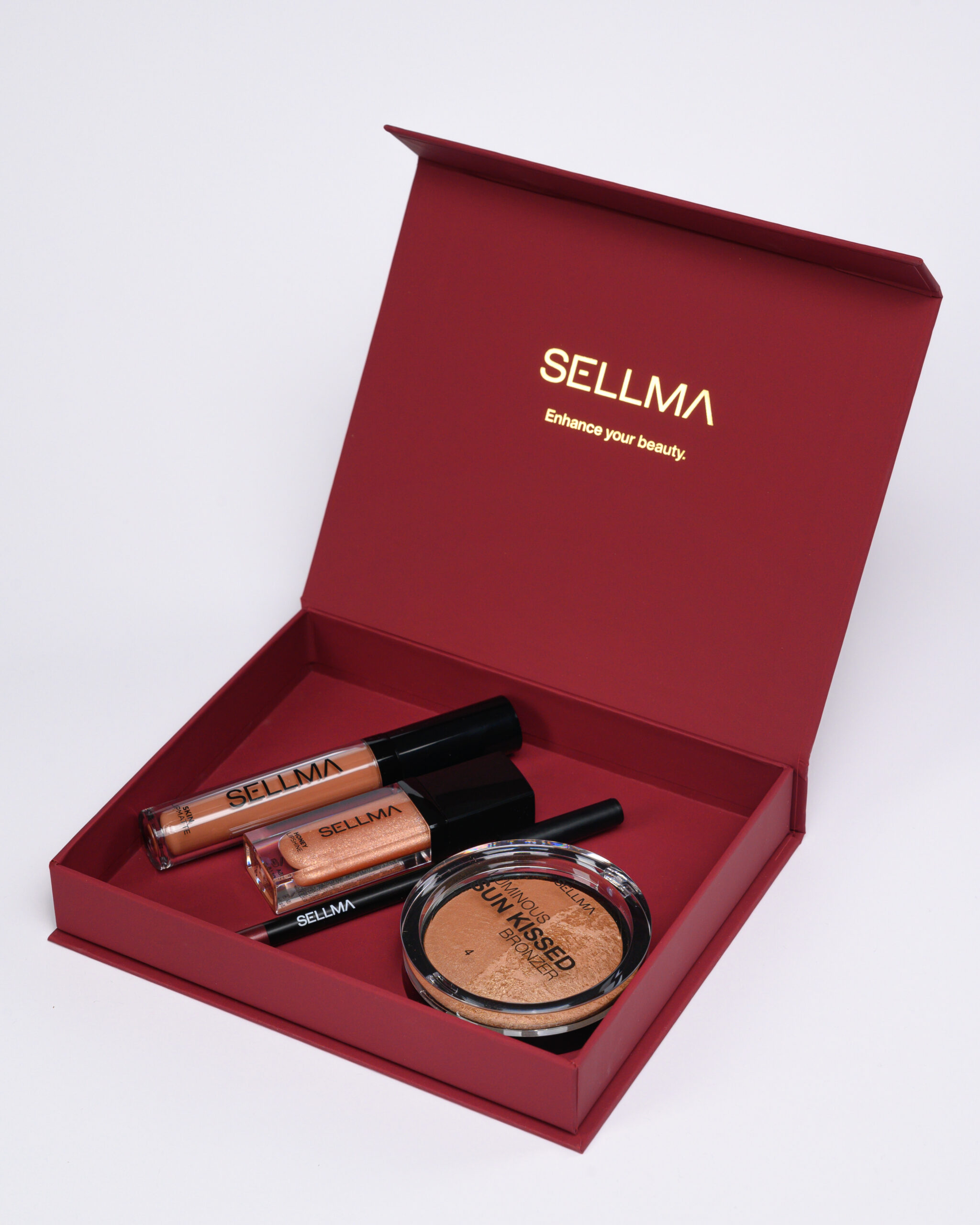 Red makeup box opened to reveal Sellma lip gloss tubes and a bronzer compact with gold lettering on the inside lid.